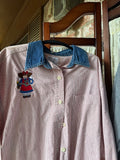 Small red stripe button-down shirt with denim collar and embroidered garden girl holding flowers.