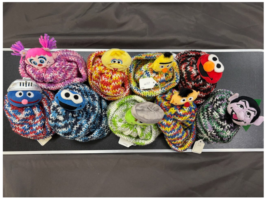 Colorful knitted or crocheted toys hanging on a string against a dark background
